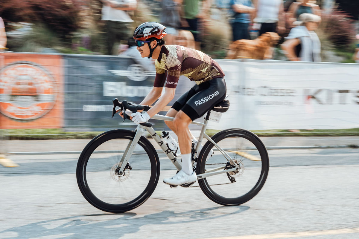 Cyclist in a Fondo passing a Blonyx Banner