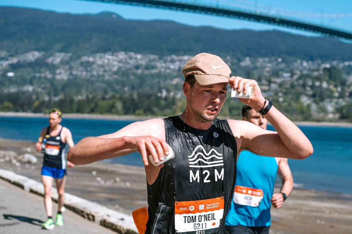 An exhausted overheated Mile 2 Marathon Runner Pours Water on his head