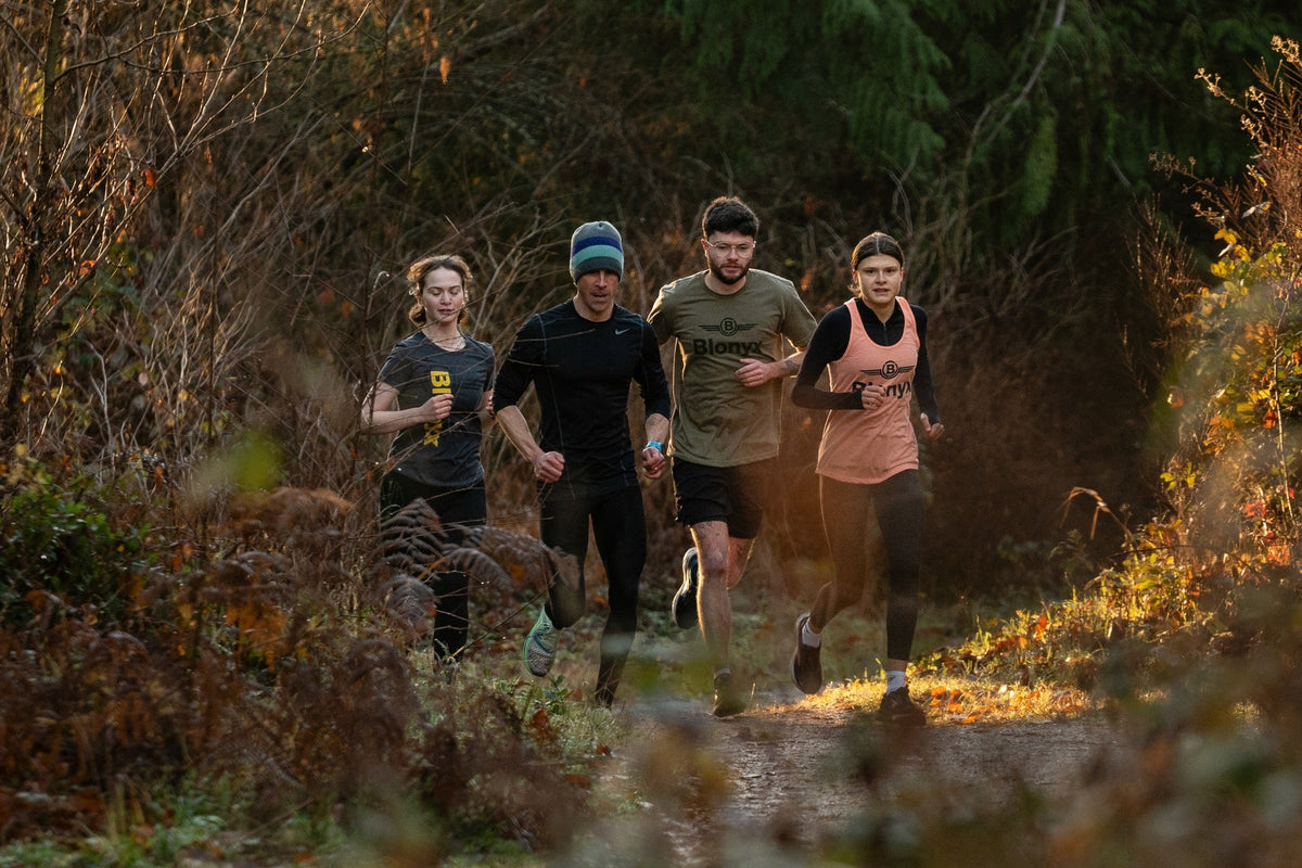 Group of runners running down a trail