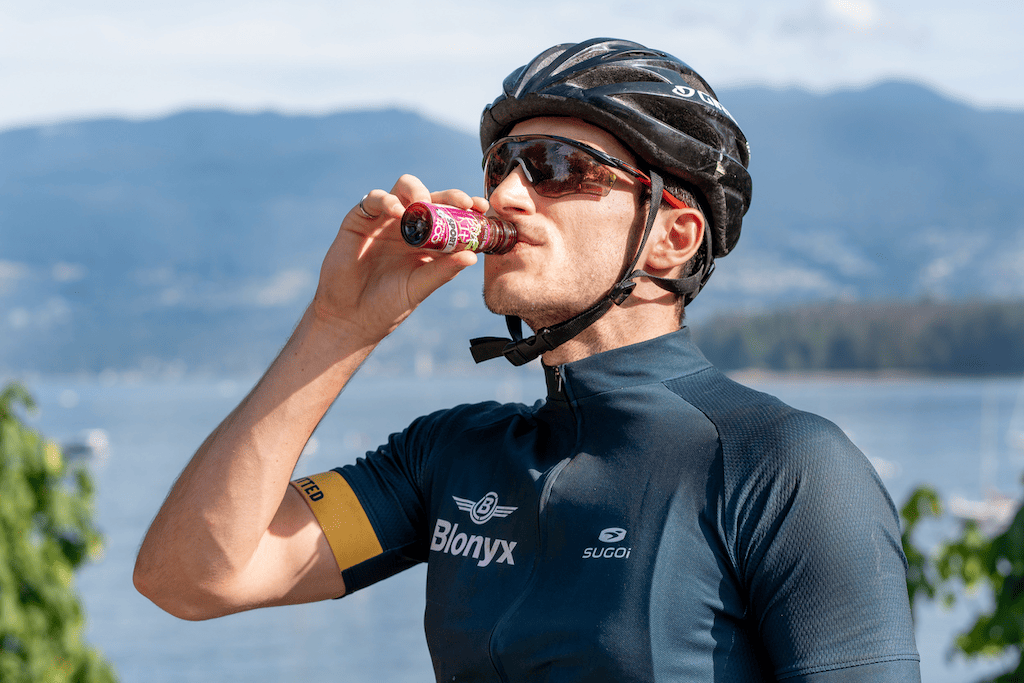 A cyclist drinking Beet It Sport Nitrate 400