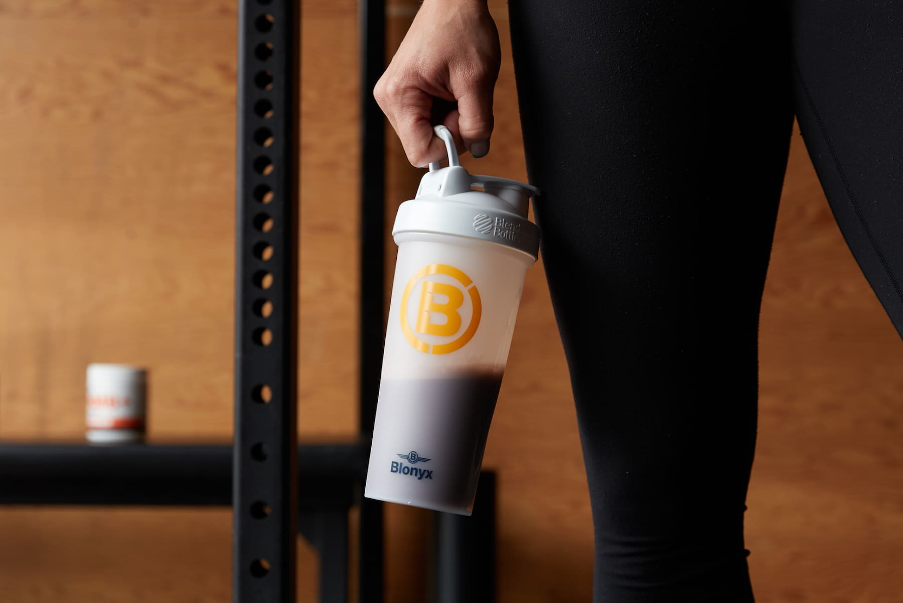Athlete holding a Blonyx shaker after training in a CrossFit gym.
