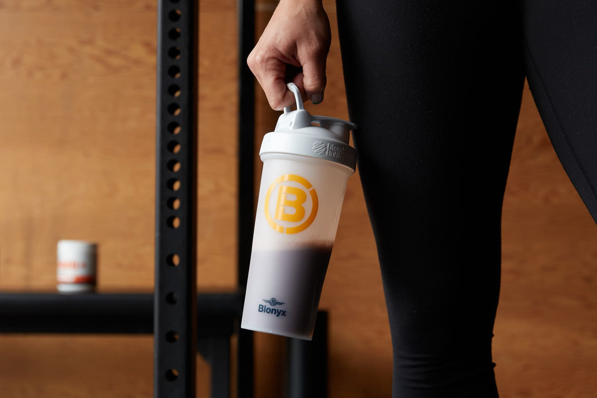 Athlete holding a Blonyx shaker after training in a CrossFit gym.