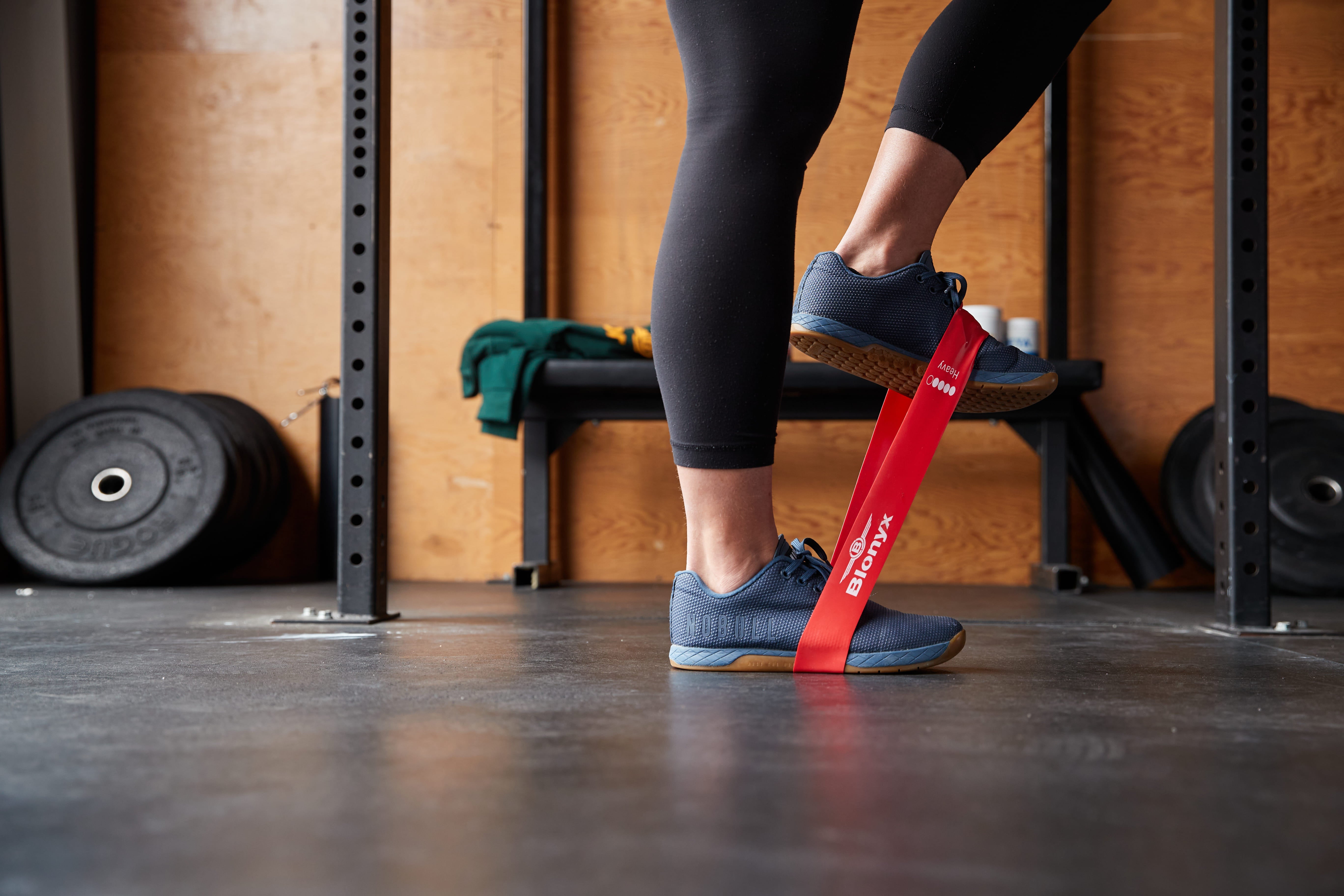 An athlete using a resistance band in a CrossFit gym