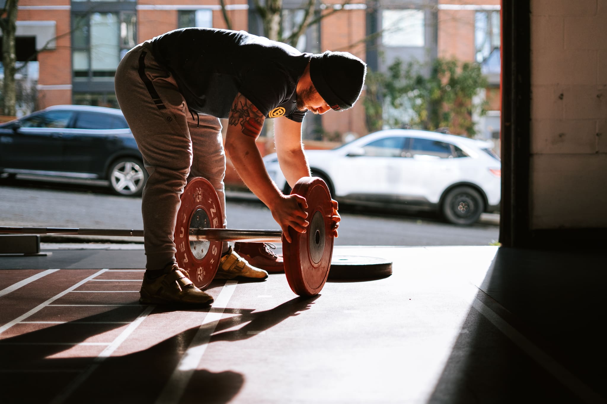 An Olympic Lifter Stacking Plates on a Barbell