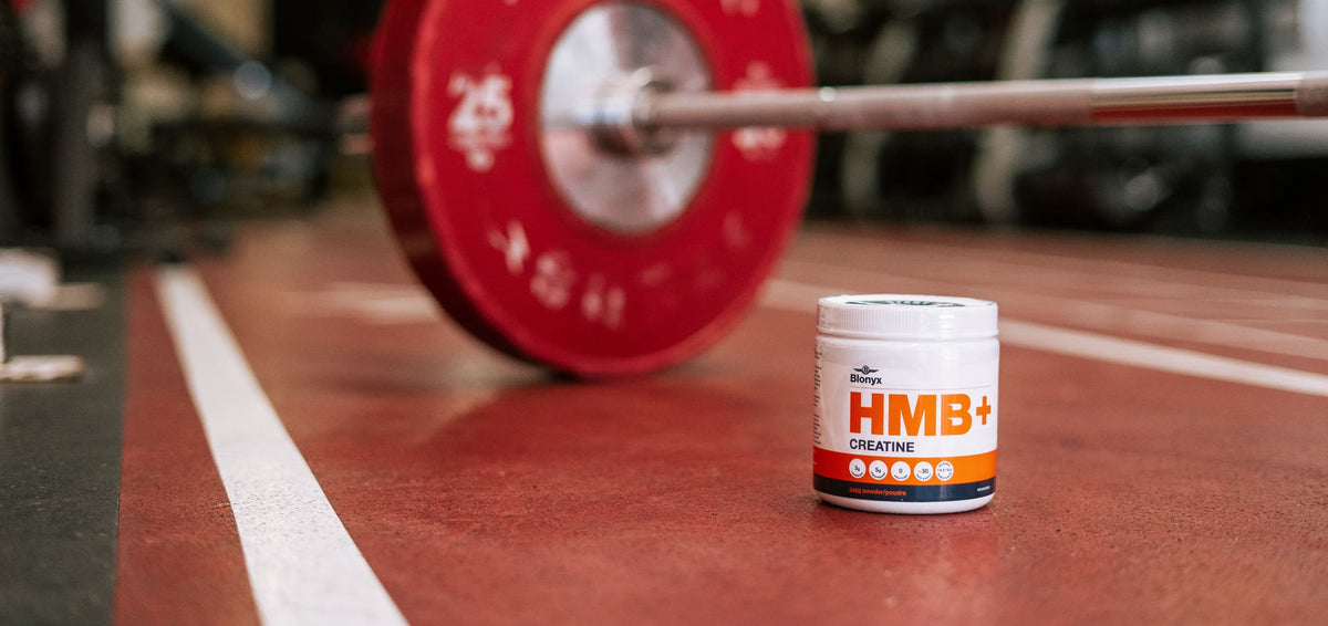 Blonyx HMB+ Creatine In Front of a Bar Bell