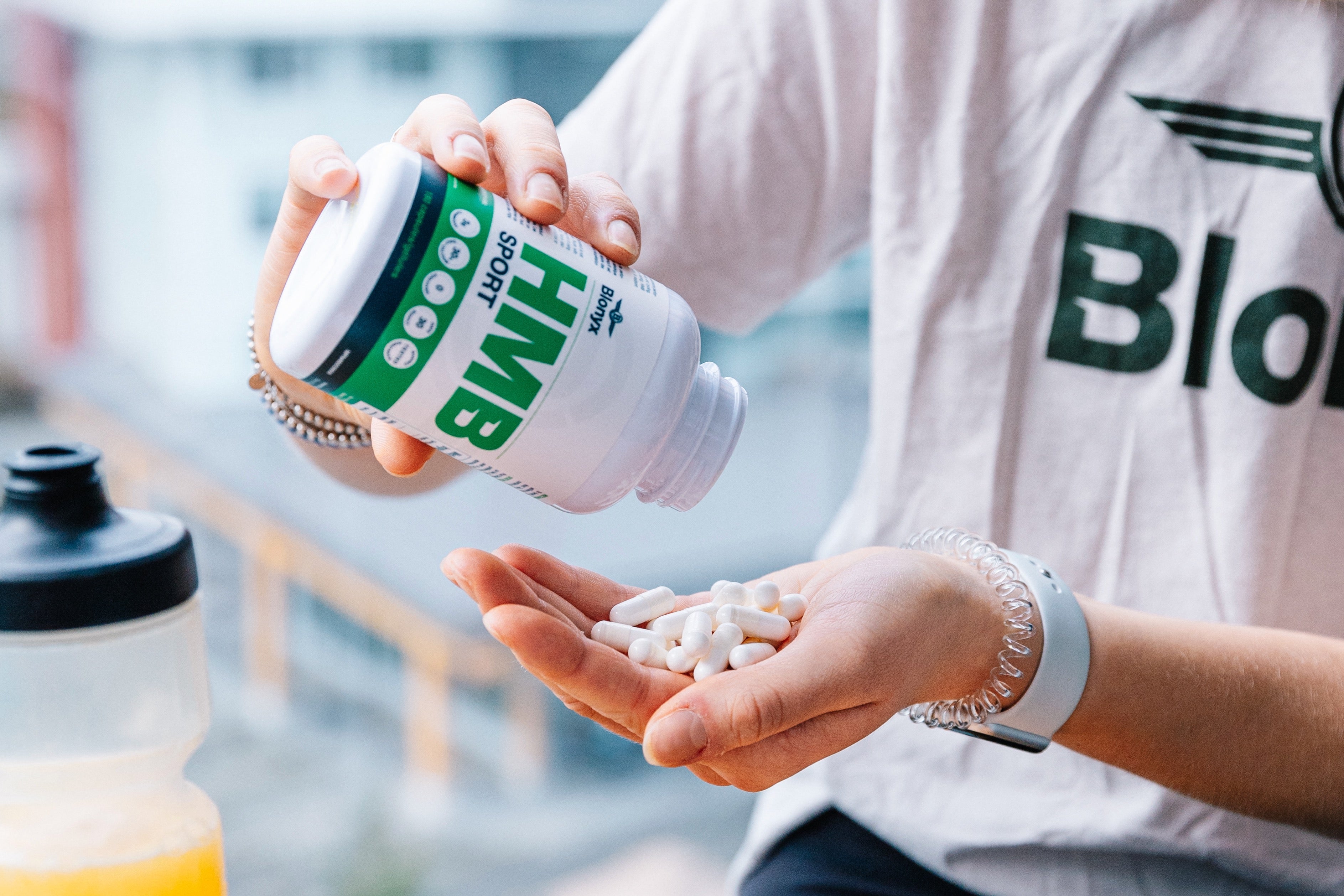 Person pouring HBM Sport capsules into their hand