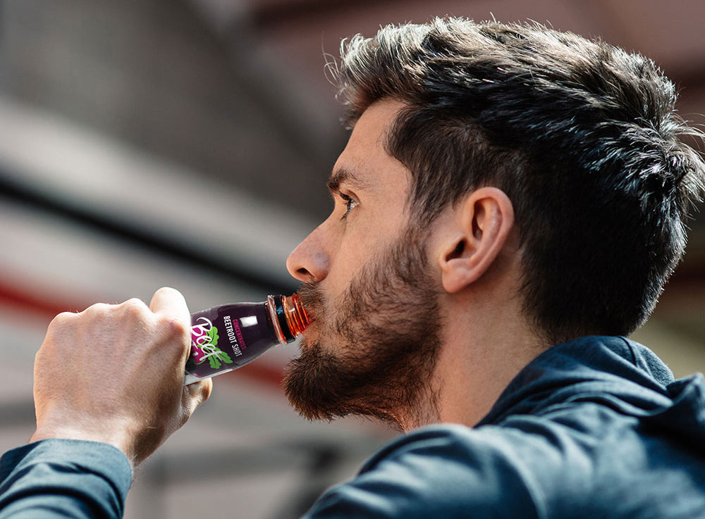 An athlete drinking Beet It Sport Nitrate 400