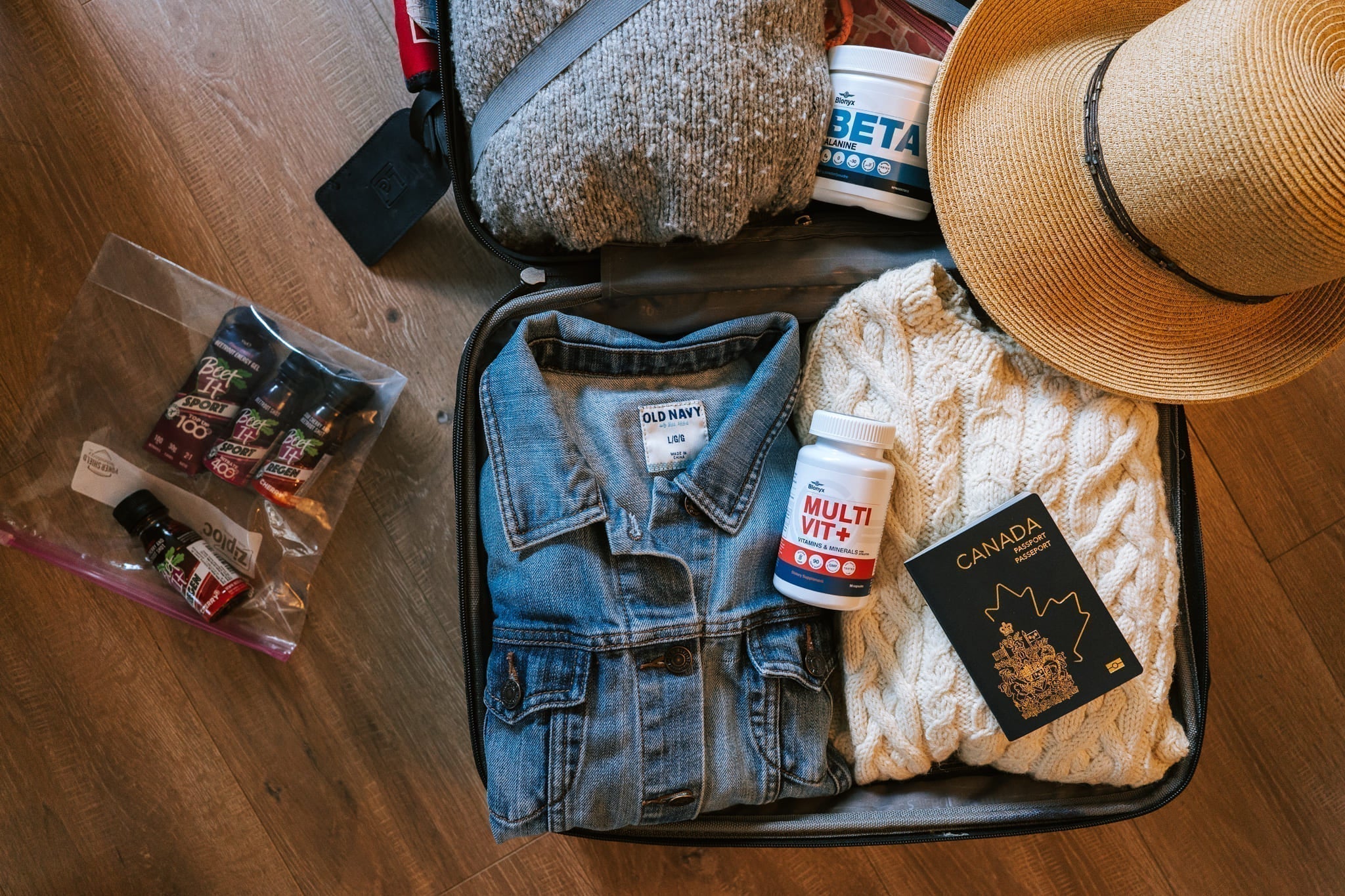Suitcase packed with sweaters and Blonyx Multivit+ and Beta Alanine