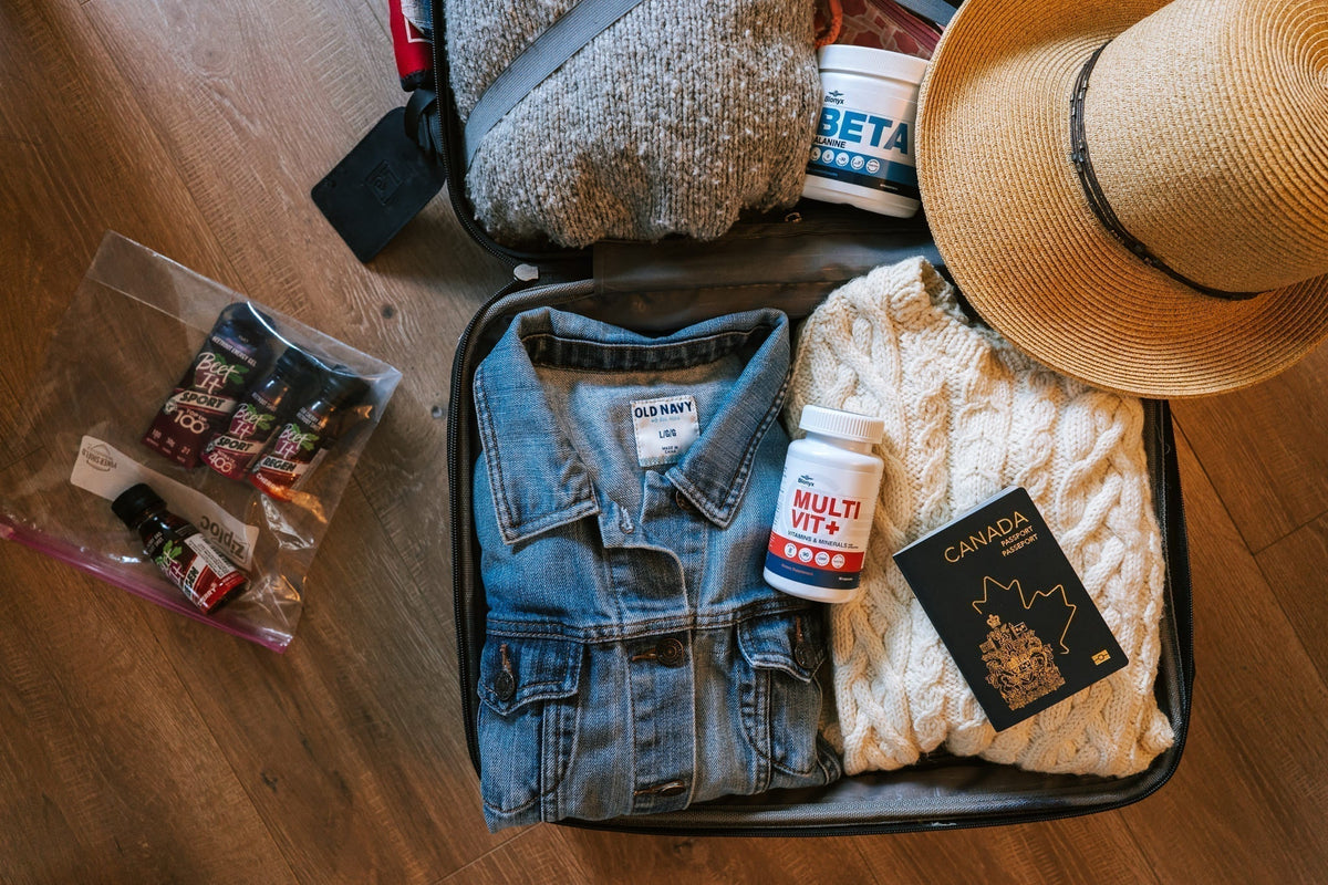 Suitcase packed with sweaters and Blonyx Multivit+ and Beta Alanine