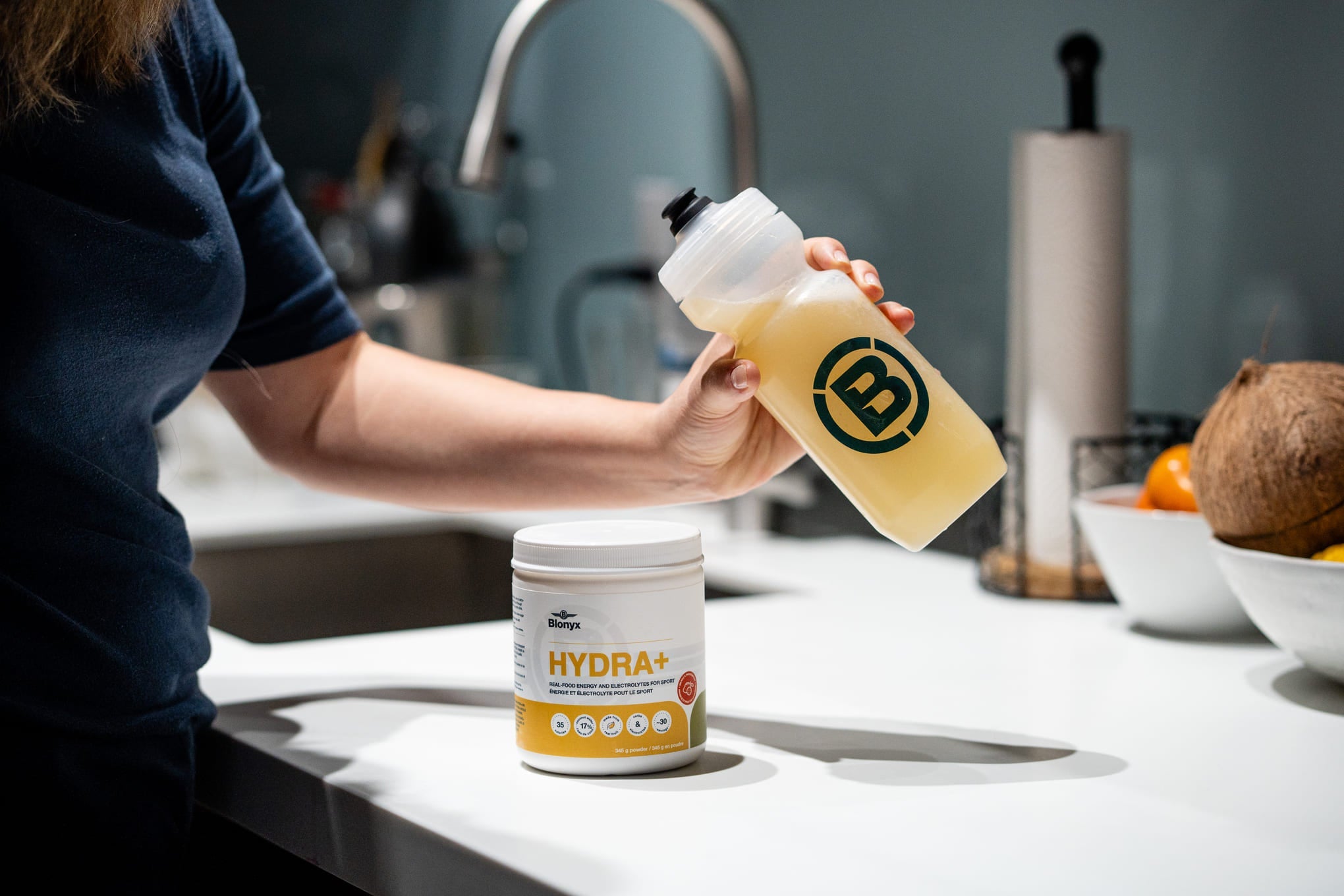 An athlete holding a bottle of Blonyx Hydra+