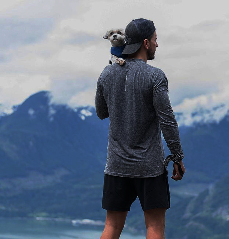 Vancouver athlete holding dog on a mountain