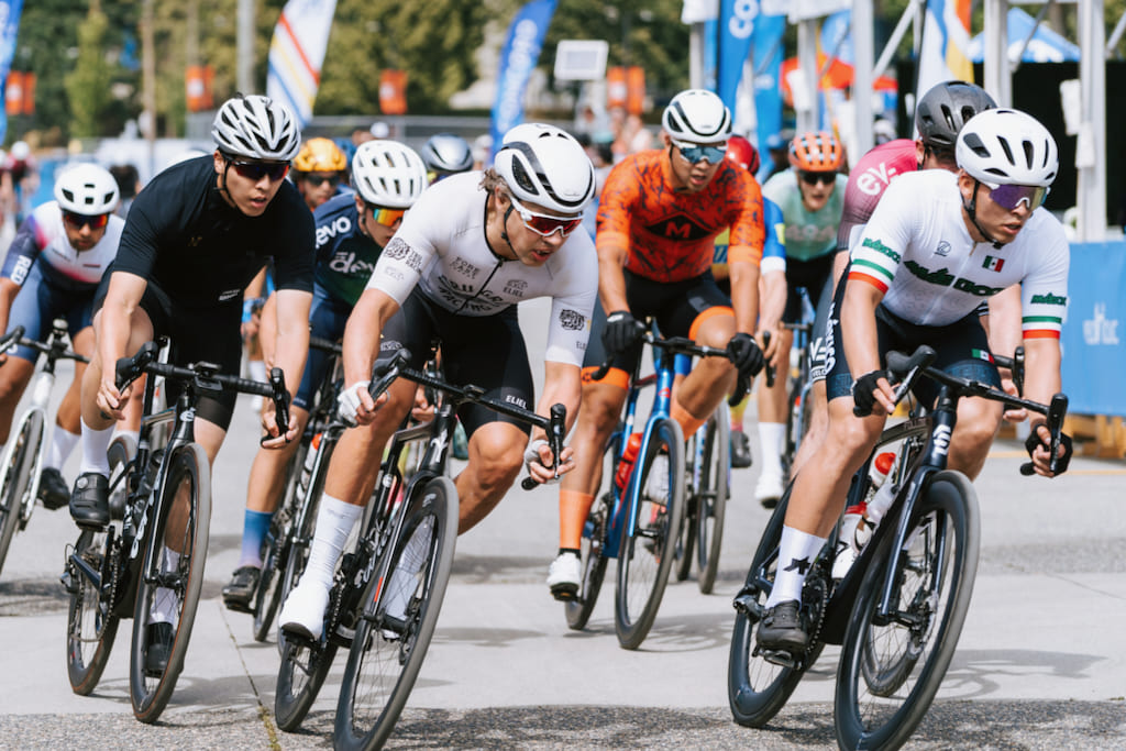 Competitive cyclists racing in road cycling criterium event during high-speed pack sprint outdoors