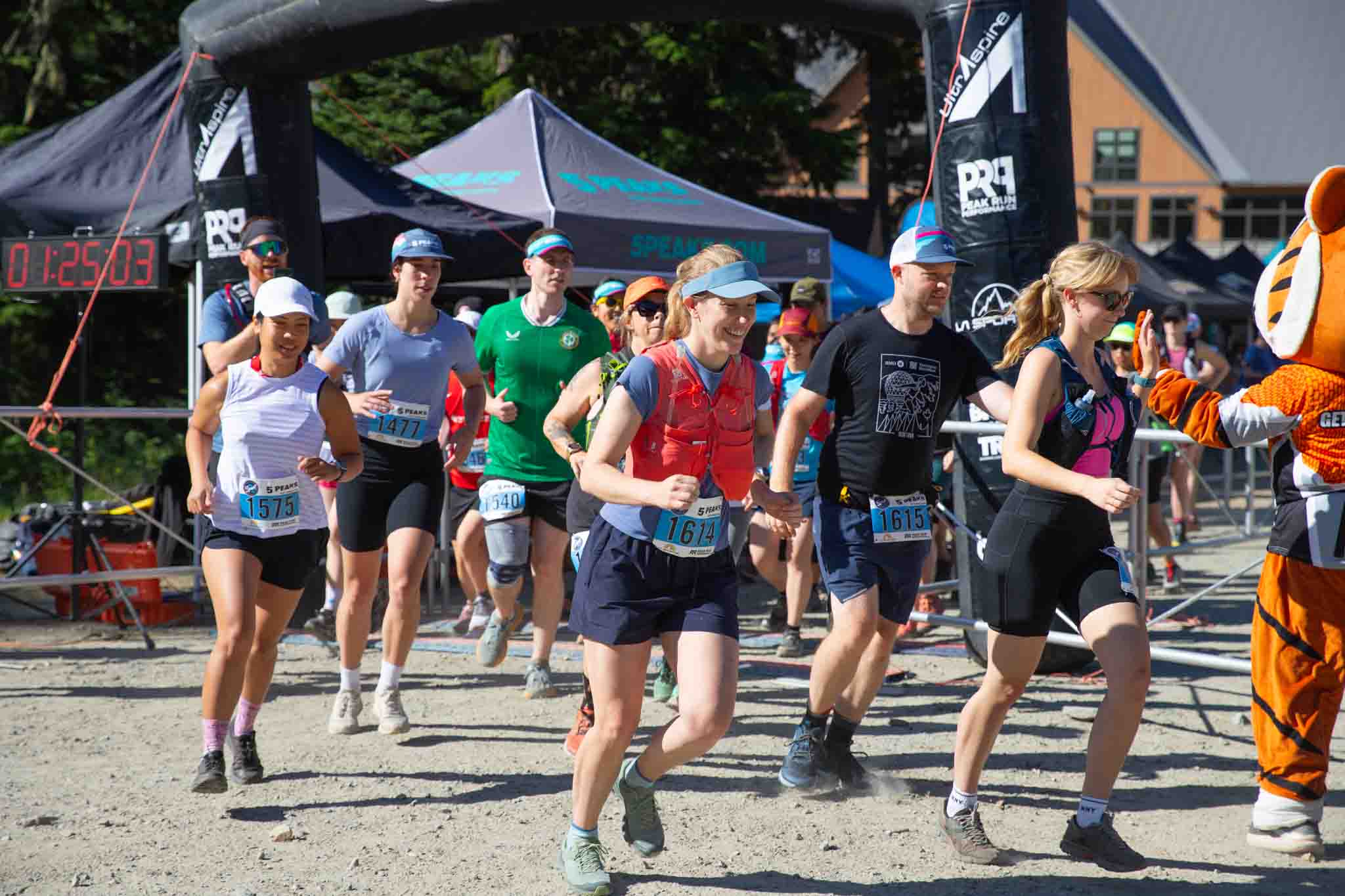 Trail runners taking off from the start line at 5 Peaks Cypress
