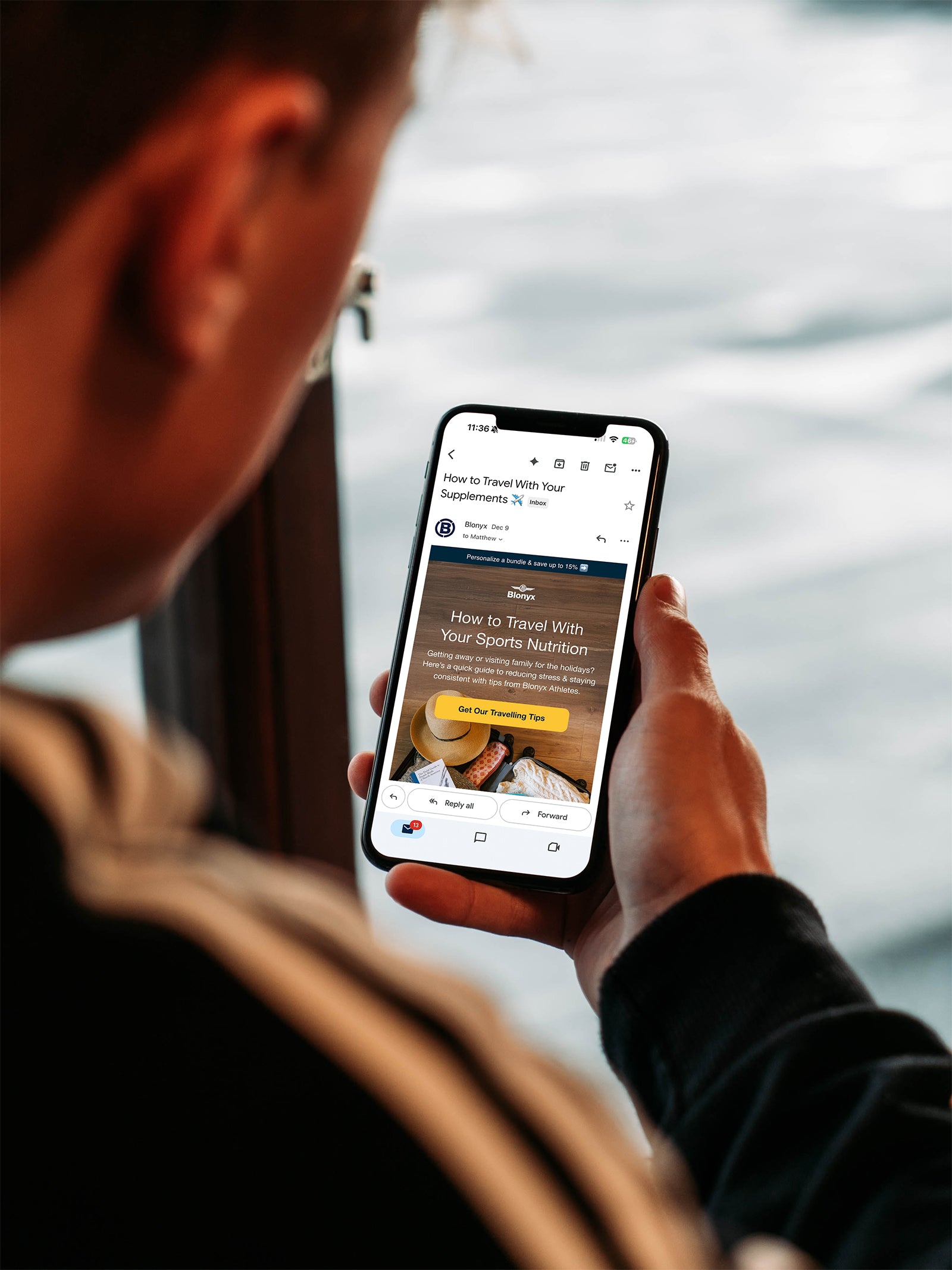 Man holding a phone and reading a Blonyx email newsletter