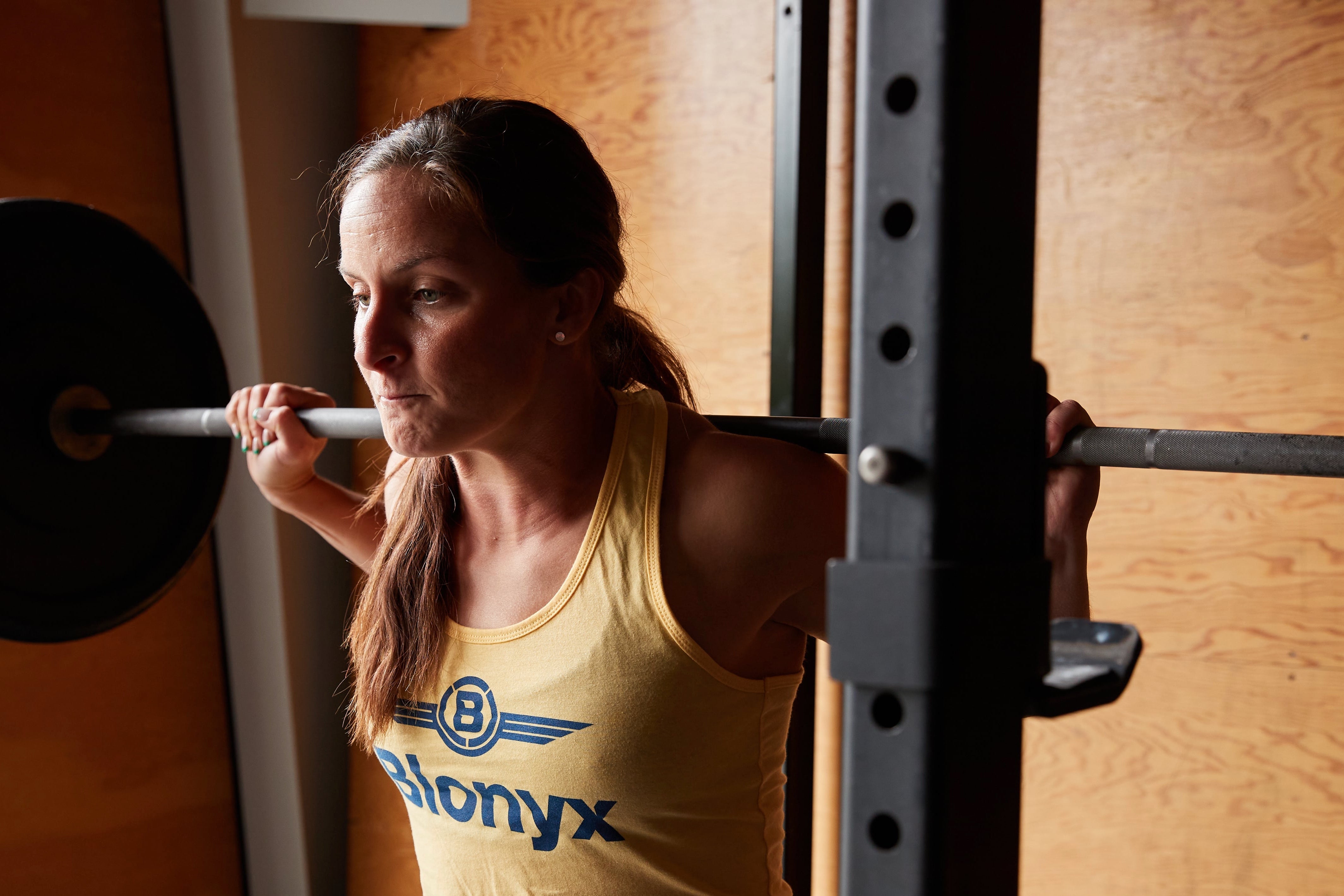 Hybrid athlete performing squats in a gym