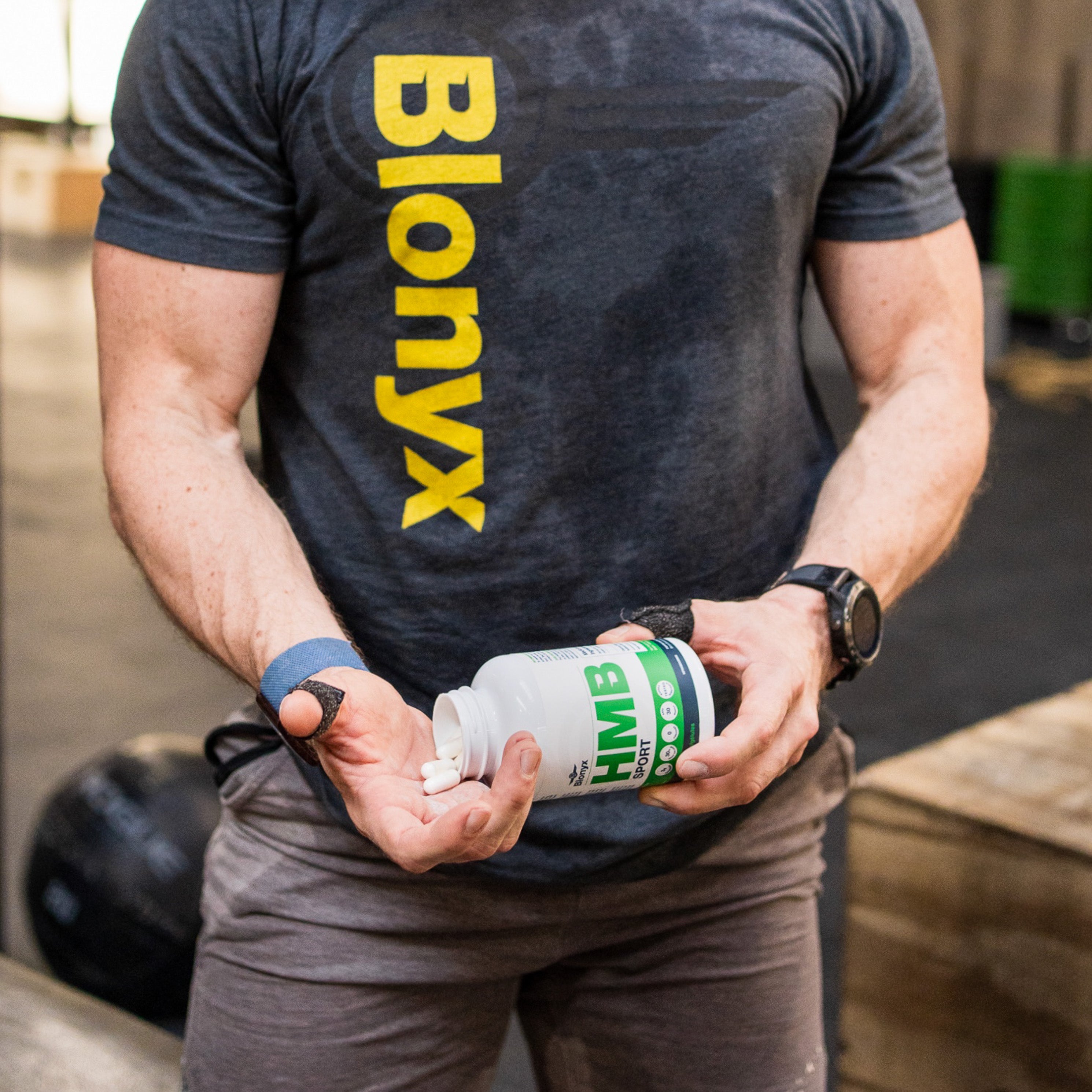 Strength athlete pouring Blonyx HMB Sport capsules into their hand