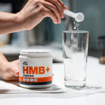 Scooping Blonyx HMB+ Creatine into a glass