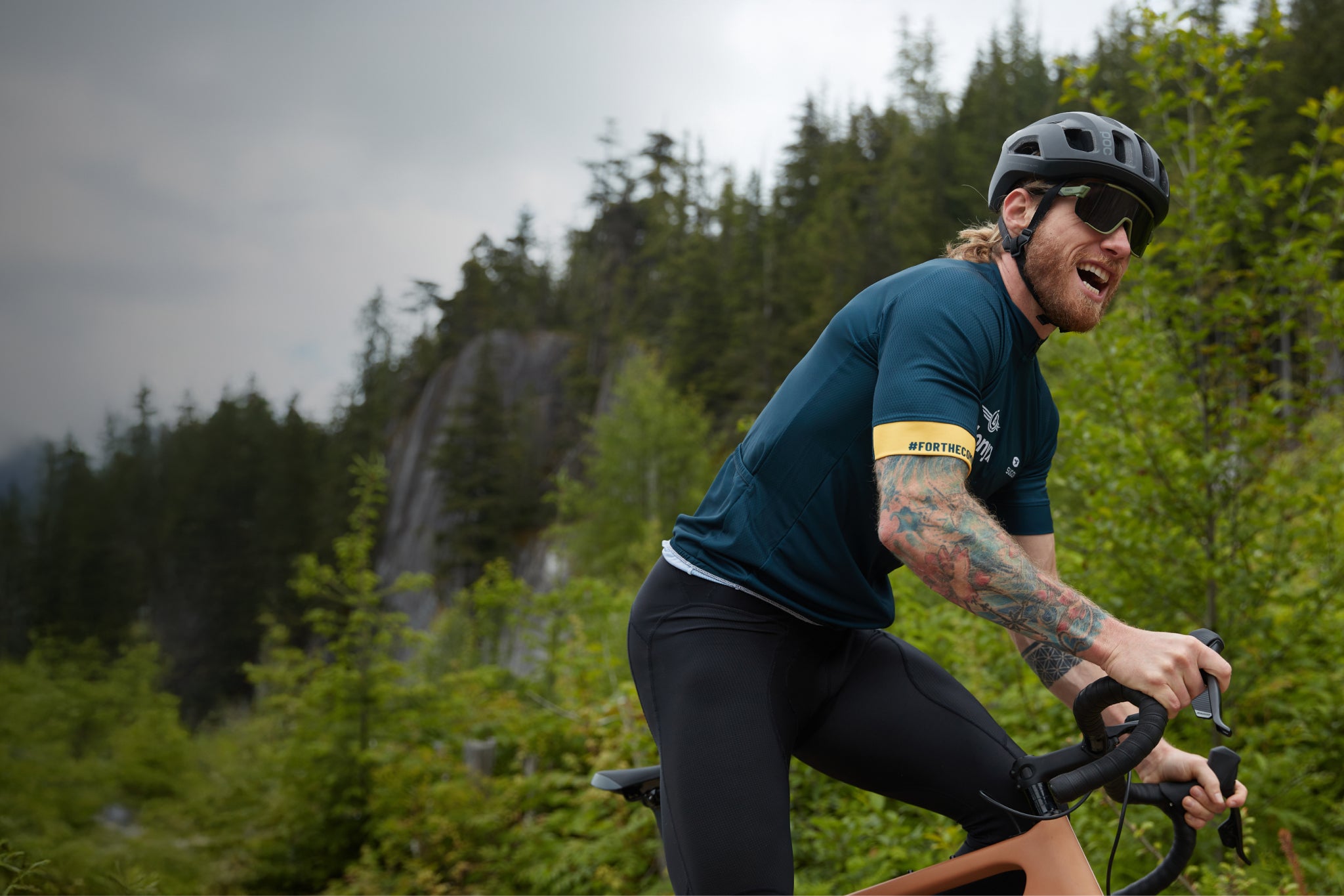 Gravel biker in Blonyx kit powering up a trail