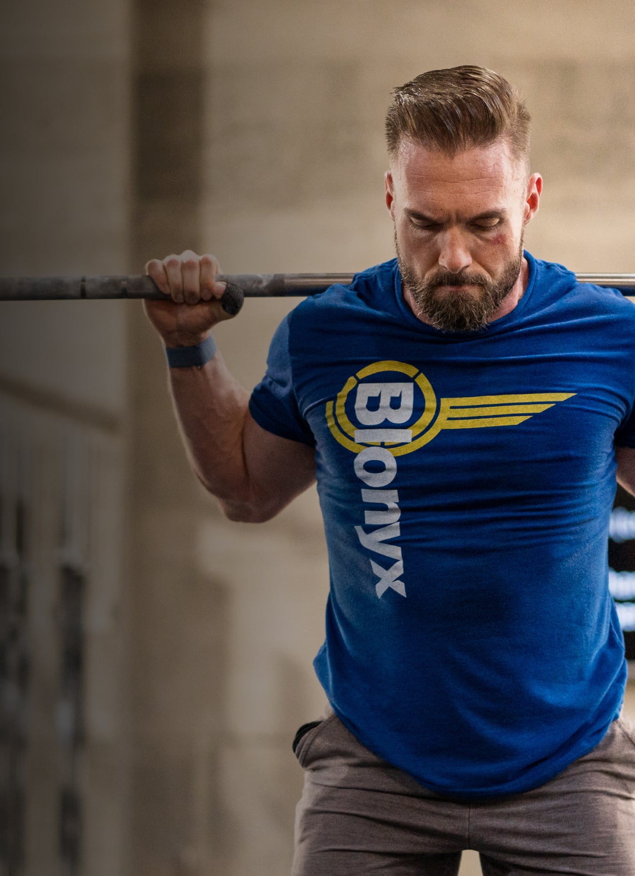 A CrossFit athlete performing squats in a blue Blonyx tee shirt