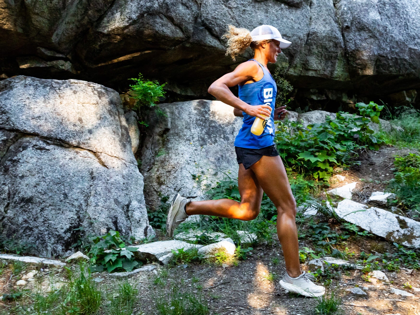 Trail runner holding a bottle of Blonyx Hydra+.