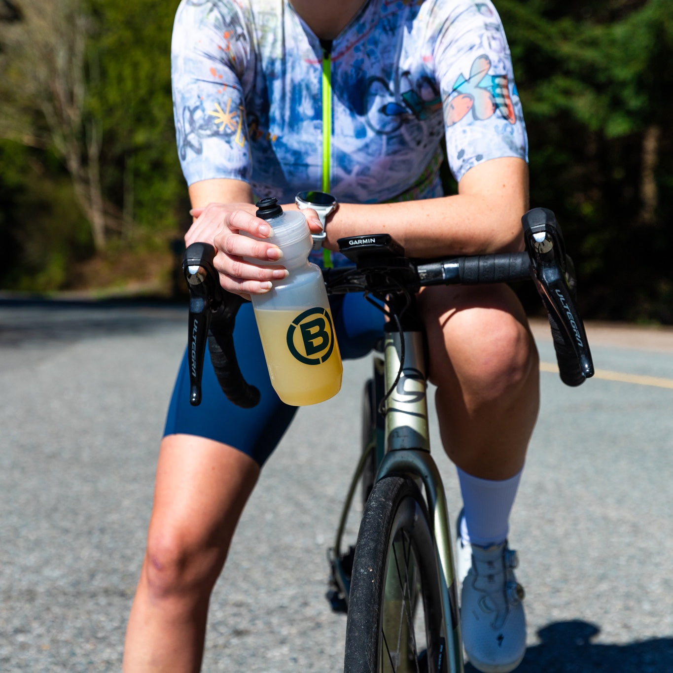 Cyclist resting with a bottle of Blonyx Hydra+