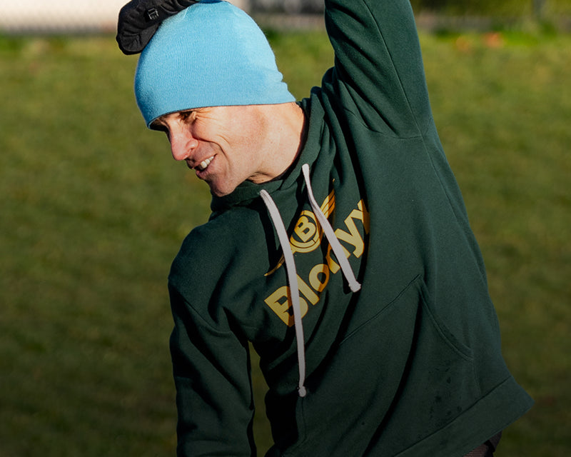 A runner stretching with their arm over their head