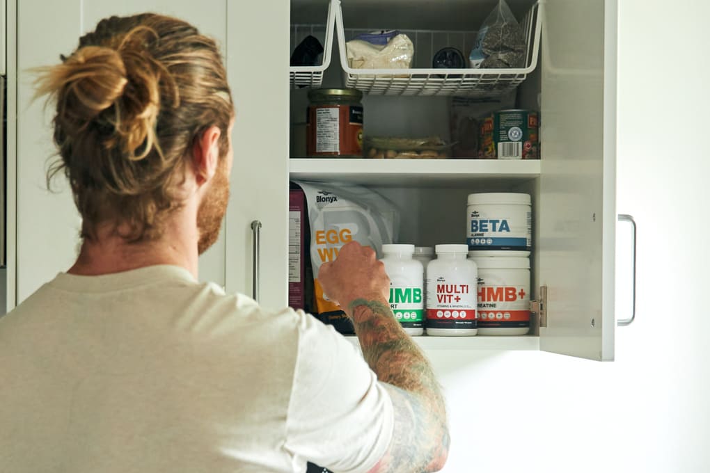 Athlete Reaching into Cabinet with Multiple Blonyx Products