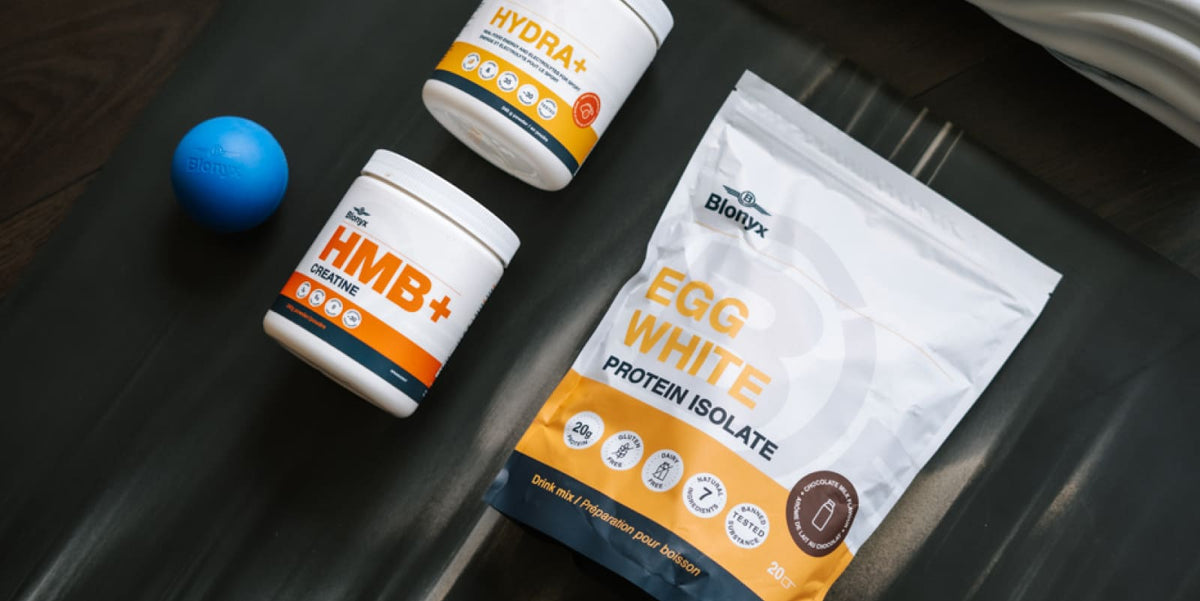 A package of Blonyx Egg White Protein Isolate alongside two supplement tubs labeled HMB+ Creatine and Hydra+ on a dark textured surface.