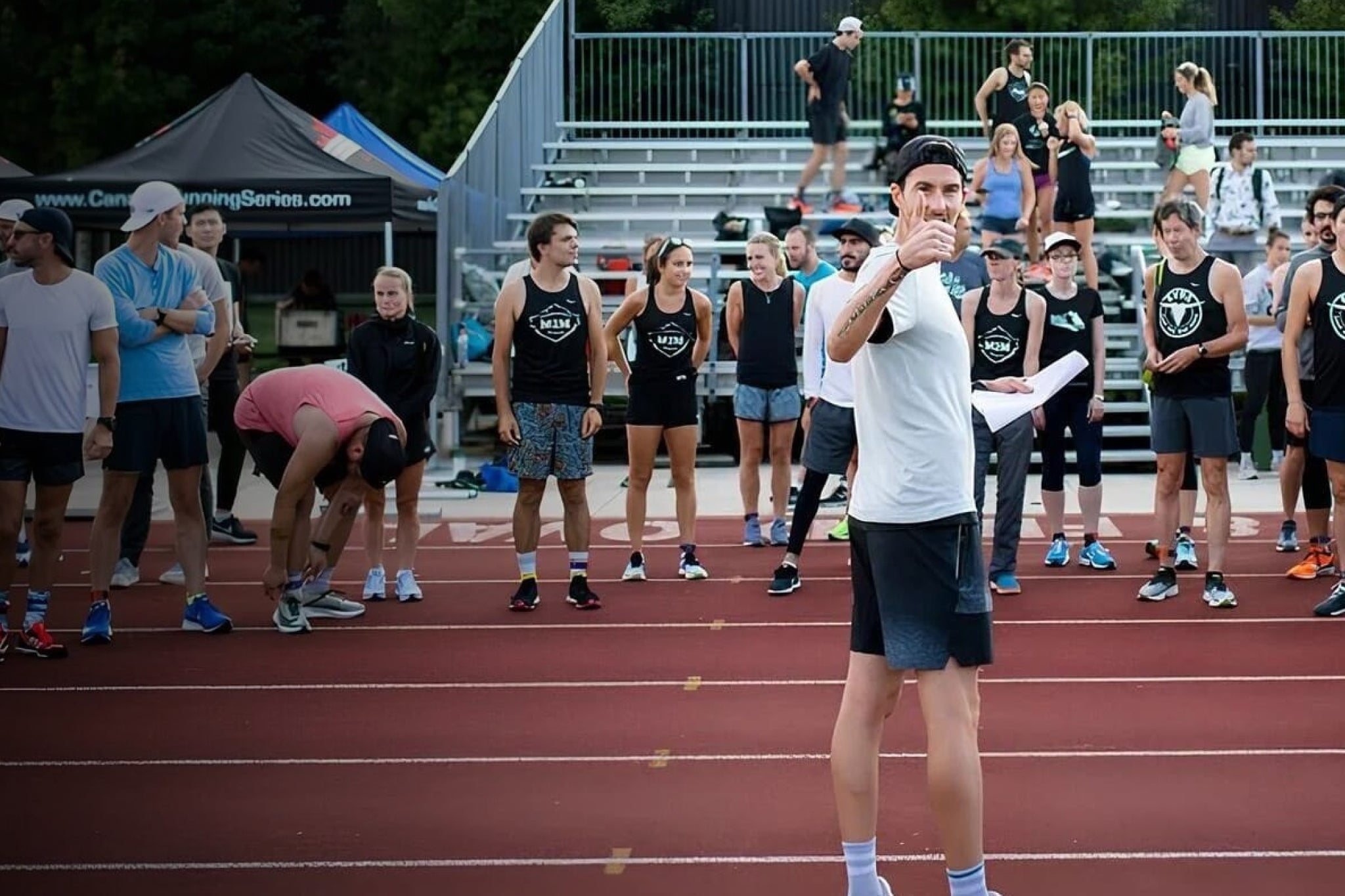 Coach Rob Watson speaking to a group of runners