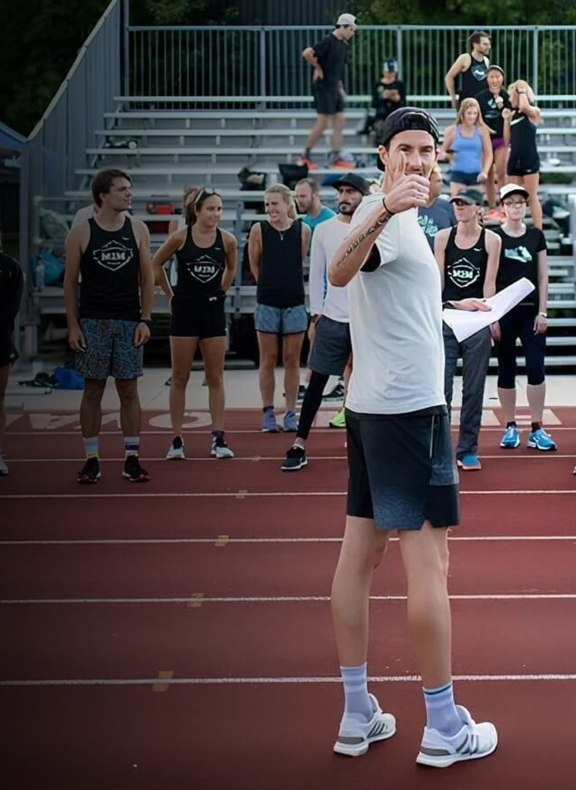 Coach Rob Watson speaking to a group of runners