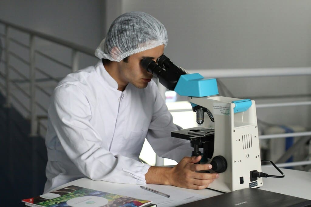 A scientist using a microscope in a lab